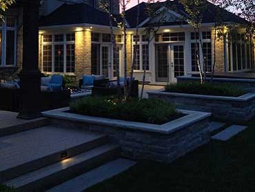 Natural stone planter with the patio and addition at night